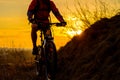 Silhouette of Enduro Cyclist Riding the Mountain Bike on the Rocky Trail at Sunset. Active Lifestyle Concept. Space for Text.