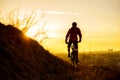 Silhouette of Enduro Cyclist Riding the Mountain Bike on the Rocky Trail at Sunset. Active Lifestyle Concept. Space for Text. Royalty Free Stock Photo
