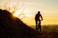 Silhouette of Enduro Cyclist Riding the Mountain Bike on the Rocky Trail at Sunset. Active Lifestyle Concept. Space for Text. Royalty Free Stock Photo