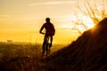 Silhouette of Enduro Cyclist Riding the Mountain Bike on the Rocky Trail at Sunset. Active Lifestyle Concept. Space for Text. Royalty Free Stock Photo