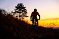 Silhouette of Enduro Cyclist Riding the Mountain Bike on the Rocky Trail at Sunset. Active Lifestyle Concept. Space for Text. Royalty Free Stock Photo