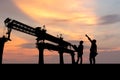 Silhouette of Engineer and foreman worker checking project at infrastructure construction site, construction site at sunset in Royalty Free Stock Photo