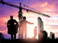 Silhouette engineer looking construction worker under tower cran in a building site over Blurred construction worker on construct Royalty Free Stock Photo