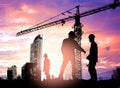 Silhouette engineer looking construction worker under tower cran in a building site over Blurred construction worker on construct Royalty Free Stock Photo