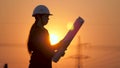 Silhouette of an engineer looks at the project of construction of a high-voltage power plant. The engineer is reading Royalty Free Stock Photo