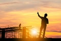 Silhouette of Engineer man with clipping path and worker on building site, construction site at sunset in evening time Royalty Free Stock Photo