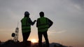 Silhouette of engineer and team At the construction site, engineers check the correctness of building structural drawings