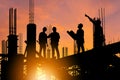 Silhouette of Engineer and worker on building site, construction site at sunset in evening time