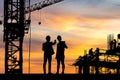 Silhouette of Engineer and worker on building site, construction site at sunset in evening time Royalty Free Stock Photo