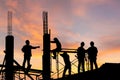 Silhouette of Engineer and worker on building site, construction site at sunset in evening time Royalty Free Stock Photo