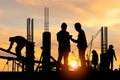 Silhouette of Engineer and worker checking project at building site background, construction site at sunset in evening time Royalty Free Stock Photo