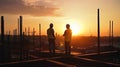 Silhouette of Engineer and worker checking project at building site background, construction site at sunset in evening time Royalty Free Stock Photo