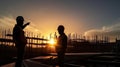 Silhouette of Engineer and worker checking project at building site background, construction site at sunset in evening time Royalty Free Stock Photo