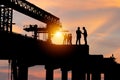 Silhouette of Engineer and worker checking project at building site background, construction site at sunset in evening time Royalty Free Stock Photo