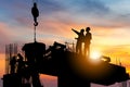 Silhouette of Engineer and worker checking project at building site background, construction site at sunset in evening time Royalty Free Stock Photo