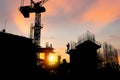 Silhouette of Engineer and worker checking project at building site background, construction site at sunset in evening time Royalty Free Stock Photo