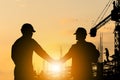 Silhouette of Engineer and worker with clipping path handshake at building site, Success team over blurred construction site at Royalty Free Stock Photo