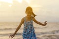 Silhouette of enjoying little girl on the beach, Kid relaxing in summer sunset sky outdoor