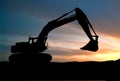 Silhouette of Excavator loader at construction site with raised