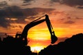 Silhouette of excavator loader  in the construction site on the sky sunset background Royalty Free Stock Photo
