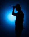 Silhouette Expressive young drummer with drum stick on a blue background