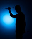 Silhouette Expressive young drummer with drum stick on a blue background