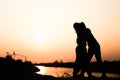 Silhouette of a family comprising a father, mother and two children happy family the sunset.Concept of friendly Royalty Free Stock Photo