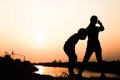 Silhouette of a family comprising a father, mother and two children happy family the sunset.Concept of friendly Royalty Free Stock Photo