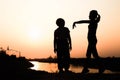 Silhouette of a family comprising a father, mother and two children happy family the sunset.Concept of friendly Royalty Free Stock Photo