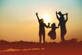 Silhouette of a family comprising a father, mother and two children happy family the sunset.Concept of friendly