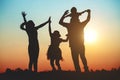 Silhouette of a family comprising a father, mother and two children happy family the sunset.Concept of friendly Royalty Free Stock Photo