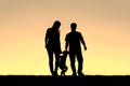 Silhouette of Family of Three People Walking at Sunset Royalty Free Stock Photo