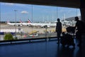 Silhouette of a family of tourists at Charles de Gaulle Airport against the background of Air France planes