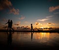 Silhouette of a family walking during sunset with reflective water