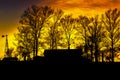 Silhouette of farmhouse with windmill and trees