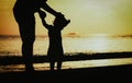 Silhouette of father and daughter learning to walk at sunset Royalty Free Stock Photo