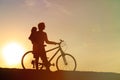 Silhouette of father and little daughter biking at sunset Royalty Free Stock Photo
