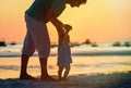 Silhouette of father and little daughter on sunset beach Royalty Free Stock Photo