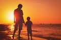 Silhouette of father and son holding hands at sunset sea Royalty Free Stock Photo