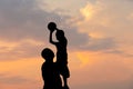 Silhouette of father and son with ball evening sky sunset background, Sport and enjoying life concepts Royalty Free Stock Photo