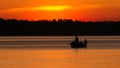 Silhouette of father and son fishing on lake at sunset Royalty Free Stock Photo