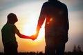 Silhouette of father and son holding hands at sunset Royalty Free Stock Photo