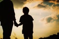 Silhouette of father and son holding hands at sunset