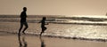 Silhouette of father and son run on summer beach outdoor, banner poster with copy space. Dad and child having fun Royalty Free Stock Photo