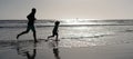 Silhouette of father and son run on summer beach outdoor, banner poster with copy space, dad and child silhouettes Royalty Free Stock Photo