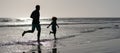 Silhouette of father and son run on summer beach outdoor, banner poster with copy space, father and son silhouettes Royalty Free Stock Photo