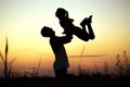 Silhouette of father throwing up his happy daughter in the air at sunset. family time togehter Royalty Free Stock Photo