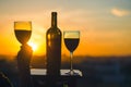 Silhouette of female hand toasting wine on sunset background.