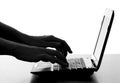 Silhouette of a female hands typing on the keyboard of the netbook Royalty Free Stock Photo