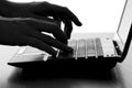 Silhouette of a female hands typing on the keyboard of the netbook Royalty Free Stock Photo